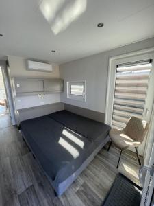 um quarto com uma cama e uma cadeira em Hausboot Dicke Bärta em Klitten