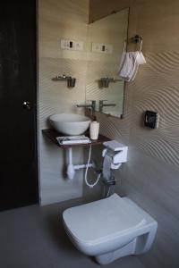 a bathroom with a white toilet and a sink at Royal Breeze Resort in Alibag