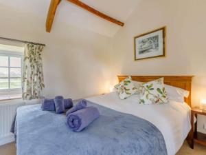 Un dormitorio con una cama con toallas moradas. en 2 Bed in Ashreigney 75412 en Ashreigney