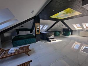 um quarto no sótão com uma cama e um sofá em Hedonic Wellness Apartmani em Niš