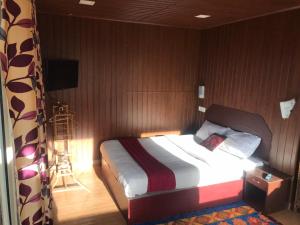 sypialnia z łóżkiem z drewnianą ścianą w obiekcie Nature Dale Munnar w mieście Munnar