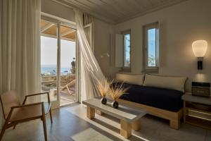 a bedroom with a bed and a view of the ocean at Summer Senses Luxury Resort in Logaras
