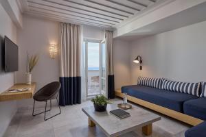 Summer Senses Luxury Resort في لوغاراس: غرفة معيشة مع أريكة زرقاء وطاولة