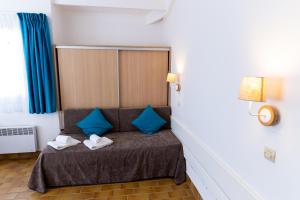 uma pequena cama com almofadas azuis num quarto em Azureva Le Grau du Roi em Le Grau-du-Roi
