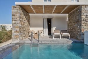 a swimming pool with two chairs and a house at Summer Senses Luxury Resort in Logaras