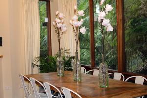 una mesa de madera con jarrones con flores rosas. en Risehill House, en Kalorama