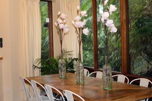 a wooden table with vases with pink flowers on it at Risehill House in Kalorama