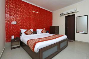 a bedroom with a large bed with a red wall at Hotel Luxury Stay Near Us embassy Delhi in New Delhi