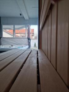 um quarto com uma cama e piso em madeira em Hedonic Wellness Apartmani em Niš