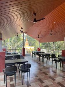 a dining area with tables and chairs in a building at Royal Breeze Resort in Alibag