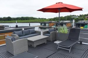 een patio met stoelen en een parasol op een boot bij Hausboot Dolce Vita in Klitten