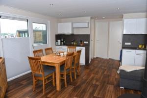 uma cozinha e sala de jantar com uma mesa de madeira e cadeiras em Hausboot Dolce Vita em Klitten