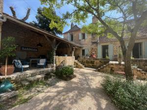 a house with a yard with a table and chairs at 1 Rue Pasquet - Double room in main house in Beaumont-du-Périgord