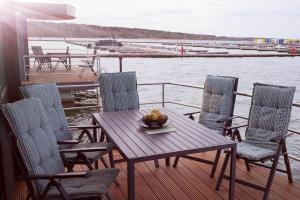 a deck with a table and chairs on a boat at Hausboot Schatzinsel in Klitten