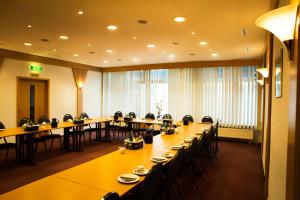 a conference room with long tables and chairs in it at Hotel Die Tanne in Goslar