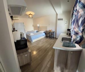 Habitación con cama y cocina con fregadero en Garden Square Inn en Markópoulon