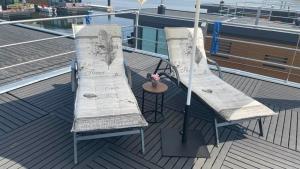 dwa krzesła na pokładzie statku wycieczkowego w obiekcie Hausboot Seestern w mieście Klitten