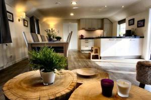 a living room with a table and a kitchen at Familiehuis De Eekhoorn - 16p in Otterlo