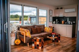 Klitten的住宿－Hausboot Skyline，一间带棕色沙发的客厅和一间厨房