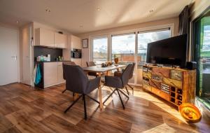 a kitchen and dining room with a table and chairs at Hausboot Skyline in Klitten