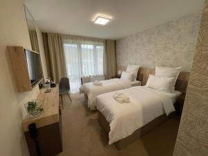 ein Hotelzimmer mit 2 Betten und einem TV in der Unterkunft Хотел Балач in Godech