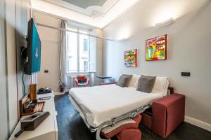 a bedroom with a bed and a red chair at Cherubini Palace Thematic Apartment in Florence