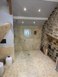 a bathroom with a shower with a stone wall at Winnie Cottage - Hot Tub, Games Room, Sauna, Large Garden in Stocksfield +82 photos