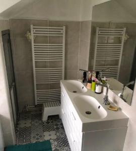 uma casa de banho branca com um lavatório e um espelho em Villa Pro em Poilly-lez-Gien