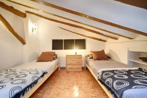 two twin beds in a room with wooden ceilings at agradable casa rural con chimenea y aire acondicionado in Vilavert +18 photos
