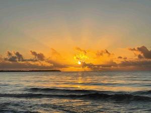 einen Sonnenuntergang über dem Meer mit Sonnenuntergang in der Unterkunft *NEW CampoMar Beachfront 2Bdrm Villa in Arroyo in Arroyo