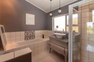 un baño con bañera y lavabo en Tranquility, en Cape St. Francis 26 fotos más