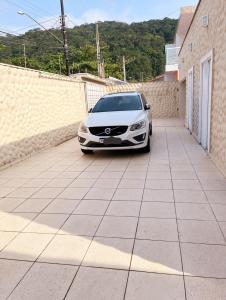 um carro branco estacionado num parque de estacionamento em CASA TEMPORADA COM PISCINA PRIVATIVA no Guarujá