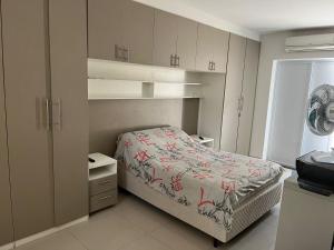 um quarto com uma cama e armários e uma janela em CASA TEMPORADA COM PISCINA PRIVATIVA no Guarujá