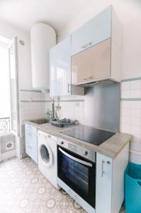 eine weiße Küche mit Waschmaschine und Trockner. in der Unterkunft Cocon proche Disneyland Paris (15 mn) in Thorigny-sur-Marne