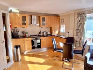 a kitchen with wooden cabinets and a table and chairs at Your Space Apartments - Market Rise in Cambridge