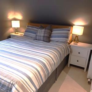 a bedroom with a bed with two night stands and two lamps at 26 Green Drive Inverness in Inshes