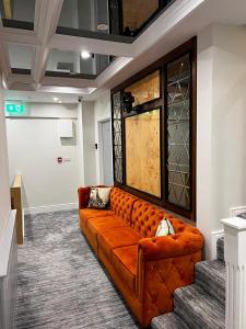 a brown couch in a room with stairs at 53 Luxury Accommodation in Maynooth