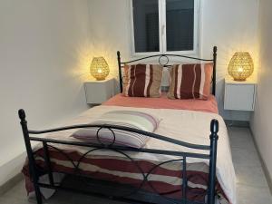 ein Schlafzimmer mit einem Bett mit zwei Lampen in der Unterkunft Beau duplex climatisé dans une villa calme. in Peymeinade