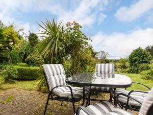 a patio with a table and chairs and a palm tree at 2 Bed in Holmesfield PK783 in Dronfield