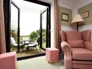 a living room with a pink chair and a patio at 2 Bed in Holmesfield PK783 in Dronfield