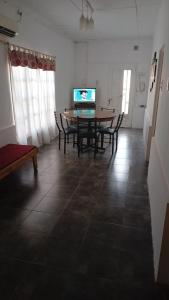 a dining room with a table and chairs and a television at Departamento céntrico San Rafael in San Rafael