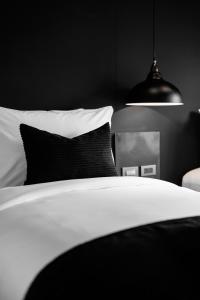 Dormitorio blanco y negro con cama y lámpara en BedTime Hotel Samui en Chaweng