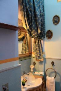 a bathroom with a sink and a mirror at Antica Corte delle Ninfee, Historical Private Villa in Trapani