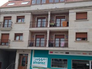 un edificio de apartamentos con balcones y una señal en él en Apartamentos As Caldelas, en O Grove