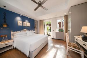 Storii By ITC Hotels Moira Riviera في Moira: غرفة نوم بسرير ابيض وجدار ازرق