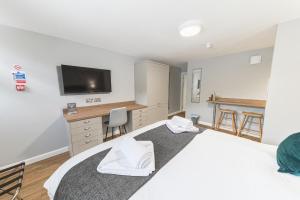 1 dormitorio con 2 camas, escritorio y TV en Chequers Lodge- Dalton-in- Furness- Self check in, en Dalton-in-Furness