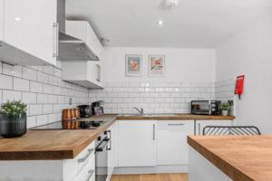 a kitchen with white cabinets and a counter top at Host & Stay - The Cavern Quarter Loft in Liverpool