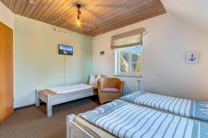a bedroom with two beds and a chair and a window at Ferienhaus Liv in Kachlin