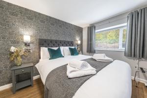 a bedroom with a large bed with towels on it at Chequers Lodge- Dalton-in- Furness- Self check in- for professionals and tourists in Dalton in Furness