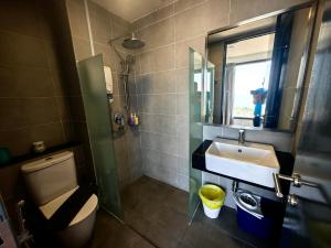 a bathroom with a sink and a toilet and a mirror at LS Tropicana 218*Sea View*1BR*Georgetown*King Bed in George Town